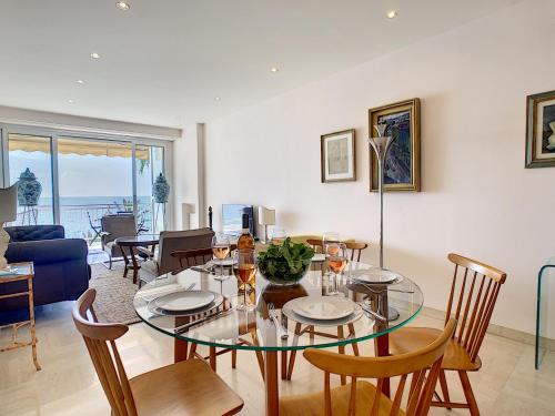 une salle à manger avec une table et des chaises en verre dans l'établissement Nestor&Jeeves - OCEAN PROMENADE - Terrace with sea view - Spacious, à Nice