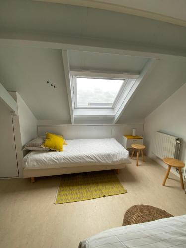 a bedroom with a bed with a yellow pillow and a window at Vakantiewoning in Middelburg Zeeland in Middelburg