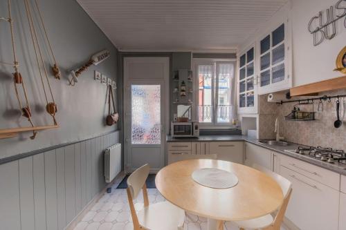 a kitchen with a wooden table and chairs in it at Maison de pêcheur LE TREPORT "ça nous va" in Le Tréport