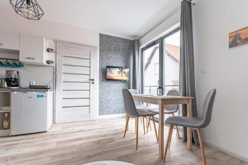 a kitchen and dining room with a table and chairs at Apartament Kapitańska in Niechorze