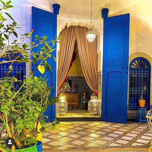 フェズにあるリヤド ジャン クロードの青いドアとソファが備わる広い客室です。
