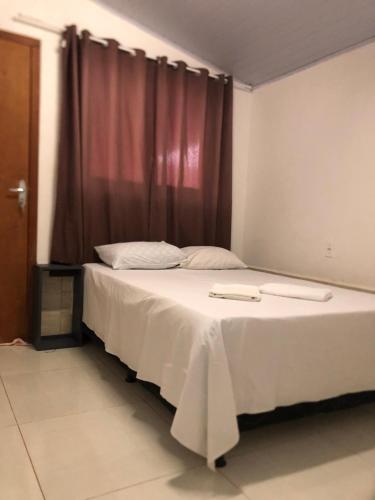 a bedroom with a bed with two trays on it at Pousada Caminho das Cachoeiras Pirenopolis in Pirenópolis