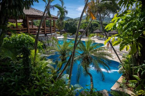 um resort com uma piscina azul com palmeiras em Pousada dos Pireneus em Pirenópolis