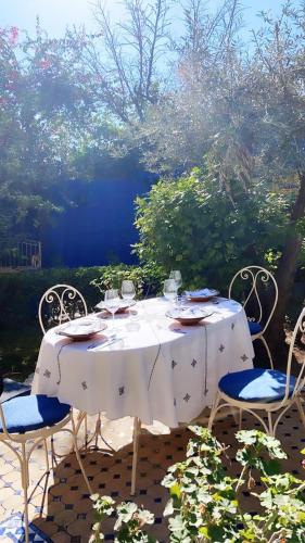 a white table with chairs and wine glasses on it at Riad Jean Claude in Fez
