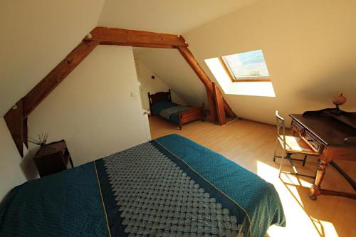 Dormitorio con cama y escritorio en el ático en Chambres et table d'hôte Le Petit Radis en Lus-la-Croix-Haute