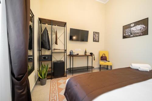 a bedroom with a bed and a desk and a television at Sweet Home Pigneto Guest House in Rome