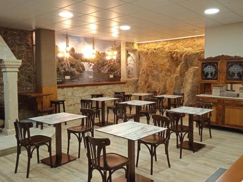 a restaurant with tables and chairs in a room at O Cabanel Albergue-Bar in Villastose