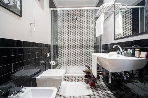 a black and white bathroom with a sink and a toilet at Sweet Home Pigneto Guest House in Rome
