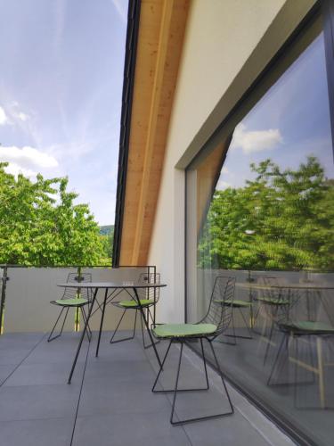 a balcony with tables and chairs and a large window at Ferienwohnungen und Zimmer in Reutlingen-Gönningen in Reutlingen
