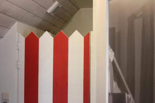 a red and white fence on the wall of a room at Miniloft Abel Abri in Zingem