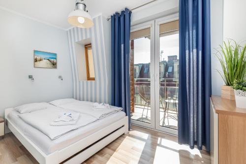 a bedroom with a bed and a large window at Apartamenty Feniks by Renters in Świnoujście