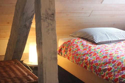 a bed with a colorful comforter in a room at Miniloft Abel Abri in Zingem
