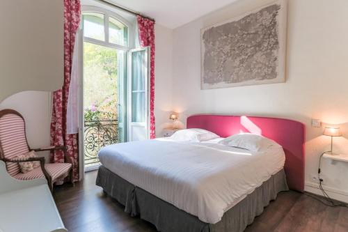 a bedroom with a large bed and a window at Logis Hôtel La Bellaudière in Grasse