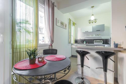 cocina con mesa y taburetes negros en una habitación en Cosy Studio at Nice Port, en Niza