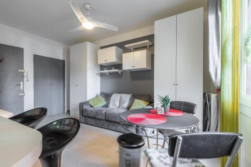 un salon avec un canapé, une table et des chaises dans l'établissement Cosy Studio at Nice Port, à Nice