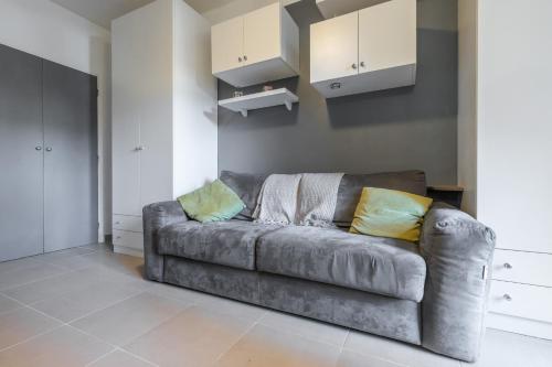 - un canapé gris dans le salon avec des oreillers jaunes dans l'établissement Cosy Studio at Nice Port, à Nice