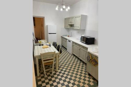 une petite cuisine avec une table et un réfrigérateur dans l'établissement Tout à pied, 100m de la plage! Grand 2 pièces cosy, à Mers-les-Bains