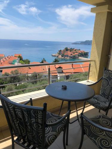 a balcony with a table and chairs and the ocean at BMV room 2 with east island view in Sveti Stefan