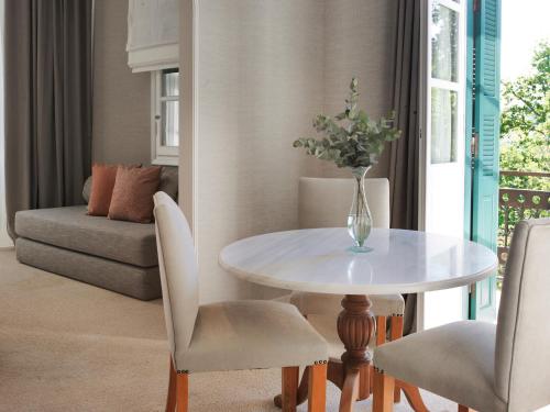 a dining room with a white table and chairs at The Kefalari Suites in Athens