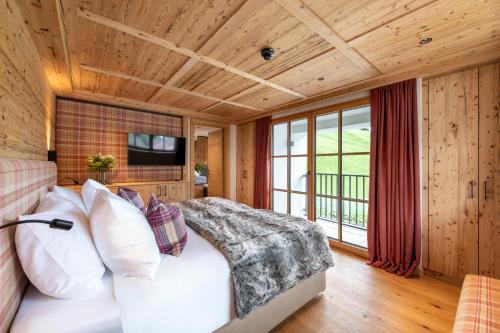 a bedroom with a bed and a television in a room at Brunnenhof Luxury Apartments in Lech am Arlberg