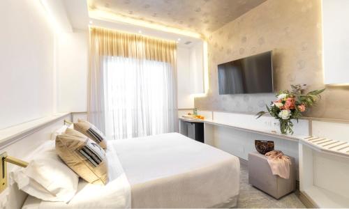 a hotel room with a bed and a television at Hotel Feldberg in Riccione