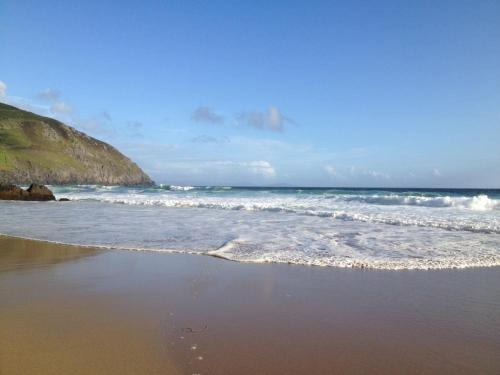 a beach with waves crashing on the shore at An Portán Guest House in Dunquin
