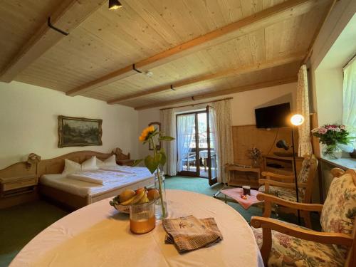 a bedroom with a bed and a table in a room at Haus Lukaswinkl in Schönau am Königssee