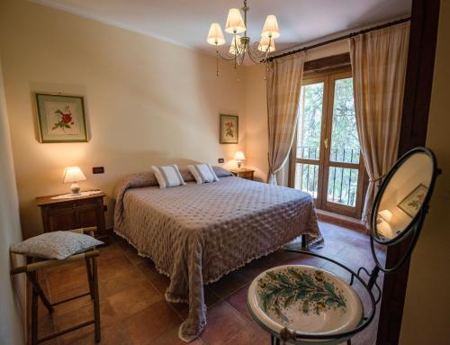 Schlafzimmer mit einem Bett, einem Spiegel und einem Fenster in der Unterkunft Podere Mocai - Cottage nel bosco in Montieri