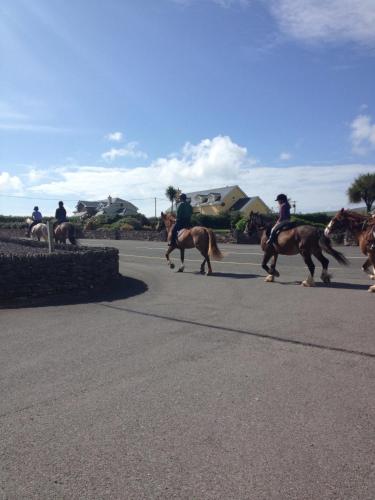 a group of people riding horses down a street at An Portán Guest House in Dunquin