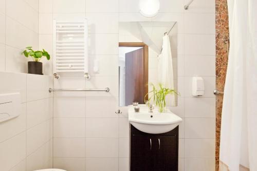 a white bathroom with a sink and a toilet at Guesthouse Baltic in Gdańsk