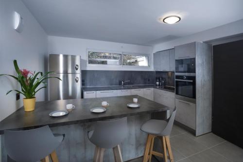 a kitchen with a large counter with chairs in it at Appartement Semnoz - Vue Lac in Sévrier