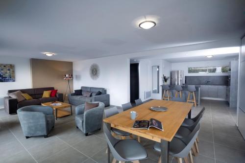 a dining room and living room with a table and chairs at Appartement Semnoz - Vue Lac in Sévrier