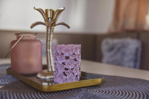 a tray with a purple candle and a vase on a table at Mobile Homes Bilice in Bilice