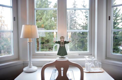 a statue of a woman on a table in front of a window at Åkerblads Hotell Gästgiveri Spa in Tällberg