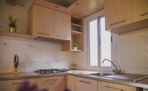 a kitchen with a sink and a stove and a window at Mobile Homes Bilice in Bilice