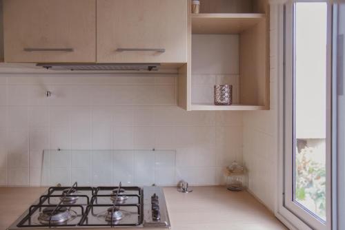 a kitchen with a stove top oven next to a window at Mobile Homes Bilice in Bilice