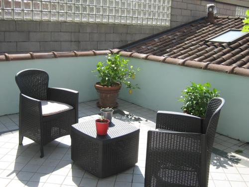 a patio with two chairs and a table and two plants at Albergo Sangalli in Boario Terme