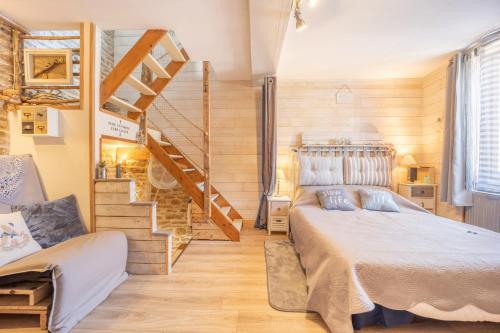 1 dormitorio con 1 cama y escalera en Le ptit passage en Saint-Aubin-sur-Mer