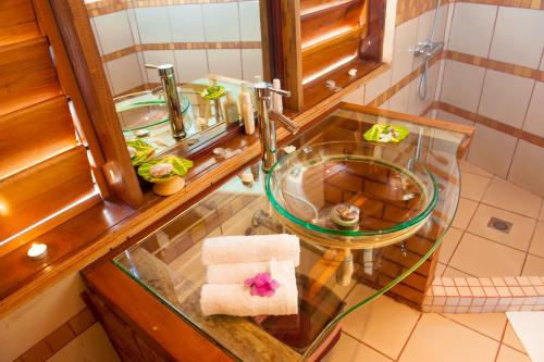 a bathroom with a glass sink and a mirror at Nosy Saba Private Island & Spa in Nosy Saba