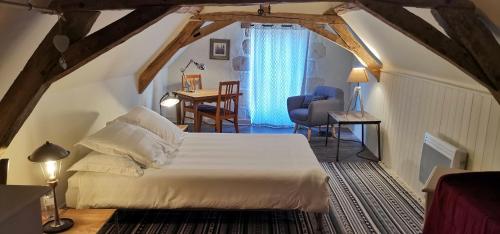 a bedroom with a bed and a desk in a room at LES LIMORNIERES in Le Grand-Pressigny
