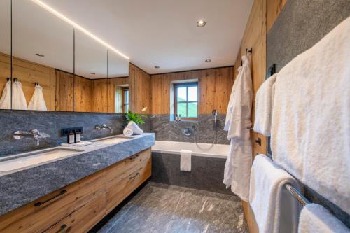 a bathroom with a large sink and a tub at Brunnenhof Luxury Apartments in Lech am Arlberg