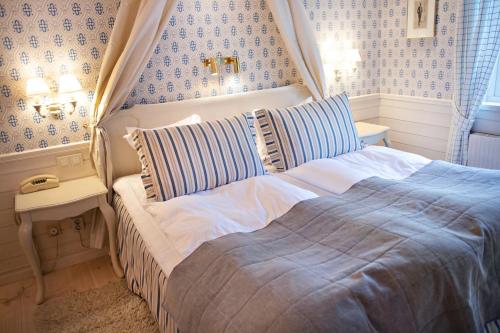 a bedroom with a bed with blue and white wallpaper at Åkerblads Hotell Gästgiveri Spa in Tällberg