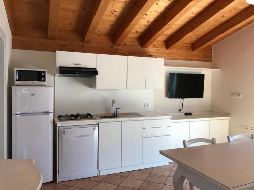 a kitchen with white cabinets and a white refrigerator at Agriturismo Maso Bergot in Arco