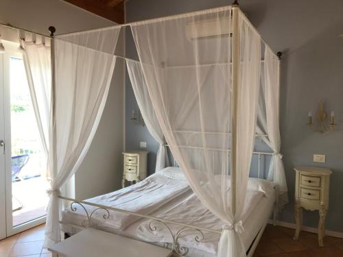 a white canopy bed in a bedroom with a window at Agriturismo Maso Bergot in Arco