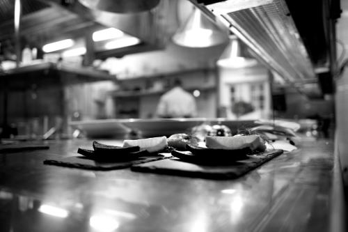 a person in a kitchen preparing food on a counter at Åkerblads Hotell Gästgiveri Spa in Tällberg