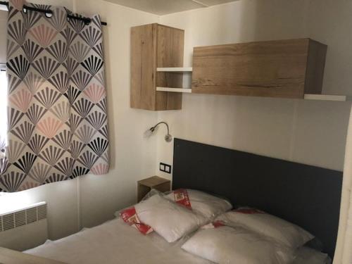 une chambre avec un lit avec une tête de lit et une fenêtre dans l'établissement Mobilhome Canet en Roussillon - CANET PLAGE LOC, à Canet