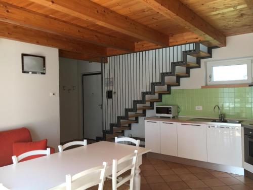 a kitchen with a white table and a staircase at Agriturismo Maso Bergot in Arco