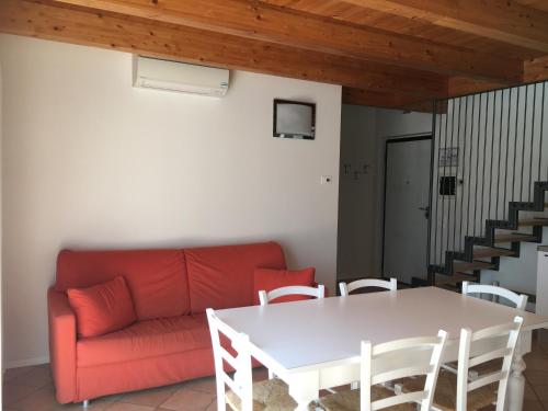 a living room with a red couch and a table at Agriturismo Maso Bergot in Arco