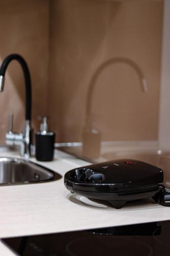 a black appliance sitting on a counter next to a sink at Alto Suite (Cielo suites) in Kavala