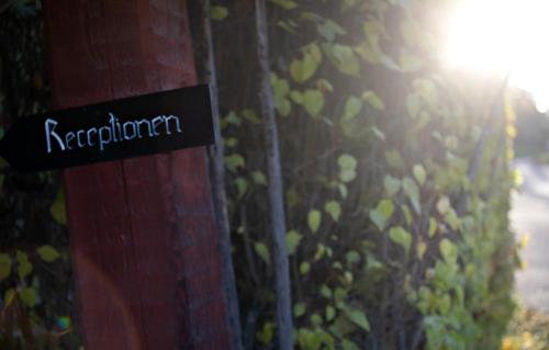 a sign on a pole in front of a bush at Åkerblads Hotell Gästgiveri Spa in Tällberg